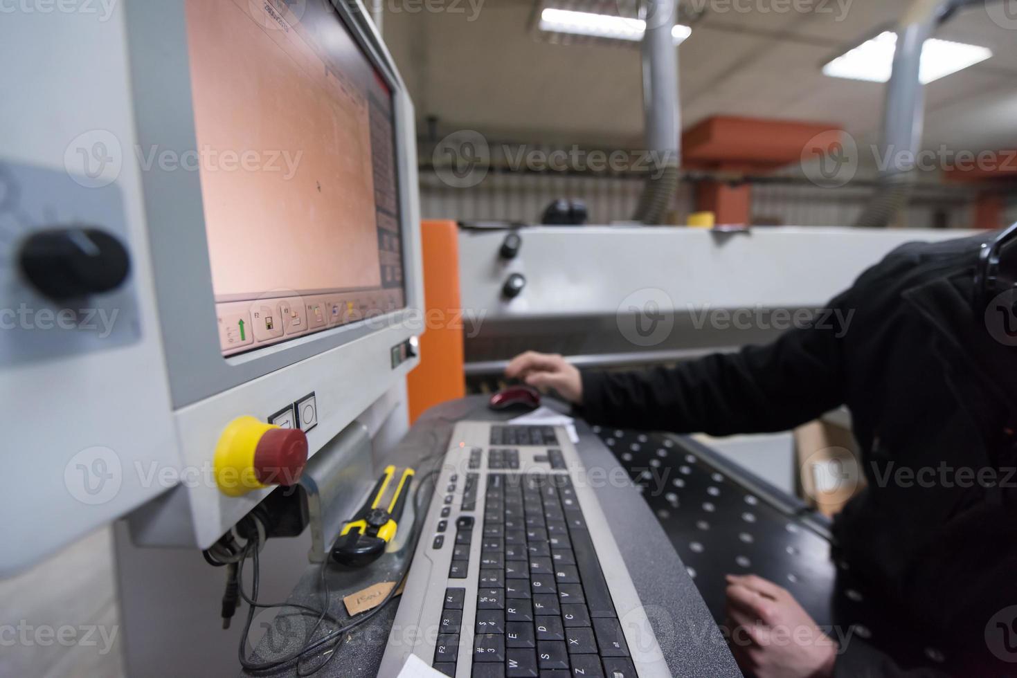 carpenters calculating and programming a cnc wood working machine photo