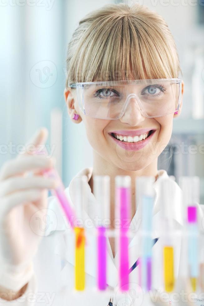 female researcher holding up a test tube in lab photo