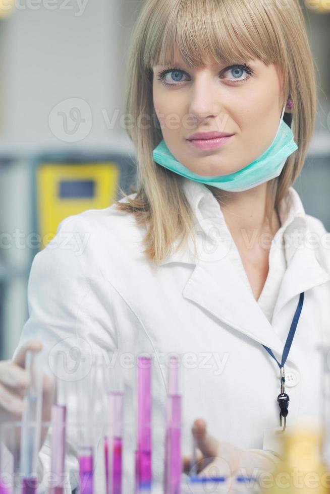 female researcher holding up a test tube in lab photo