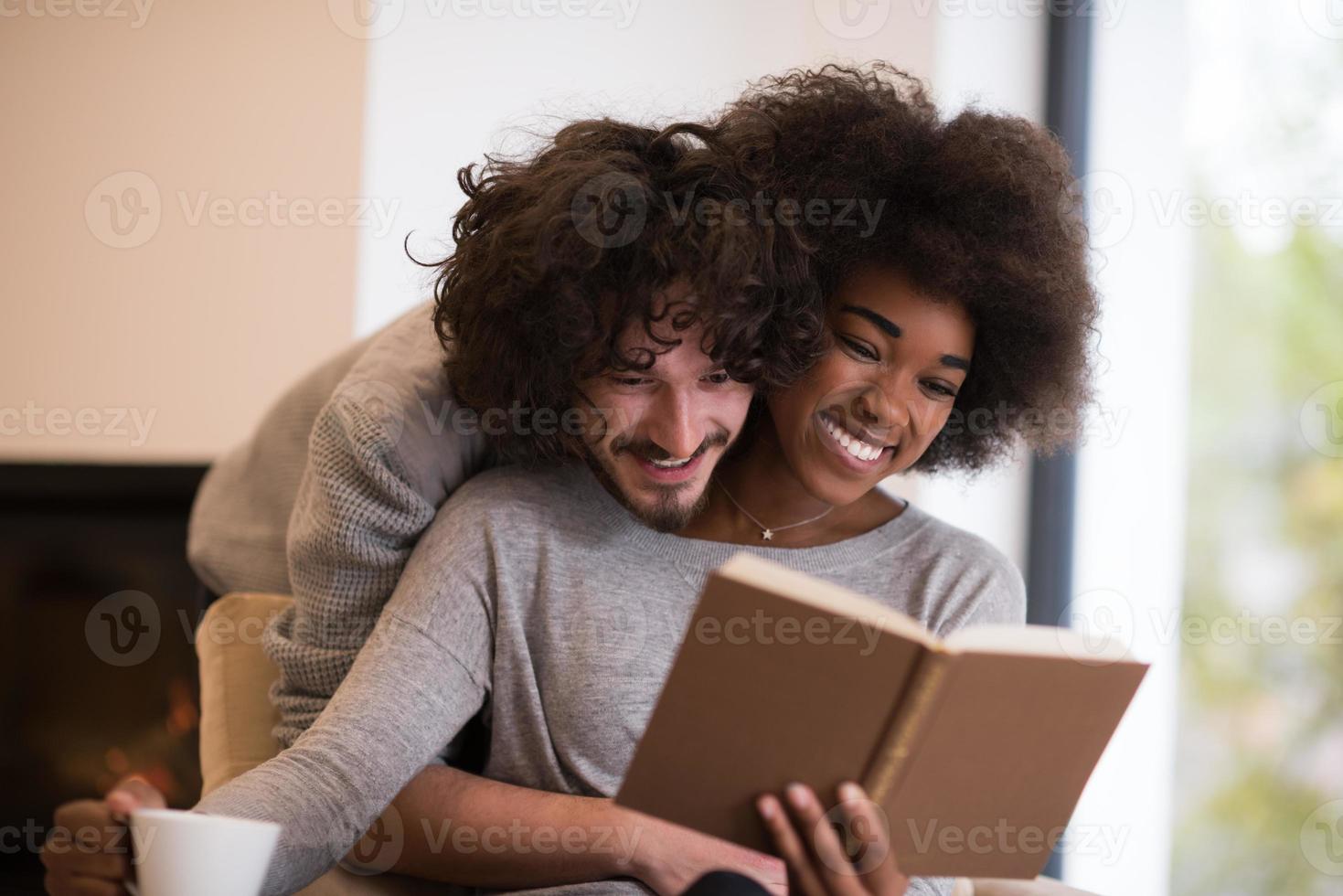 multiethnic couple hugging in front of fireplace photo