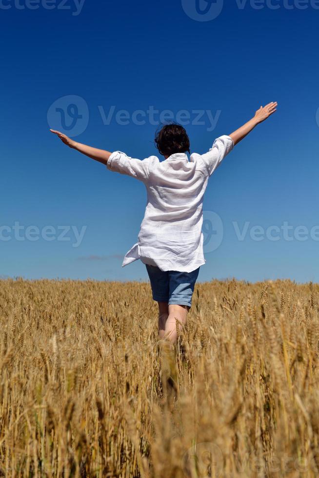 mujer joven en campo de trigo en verano foto