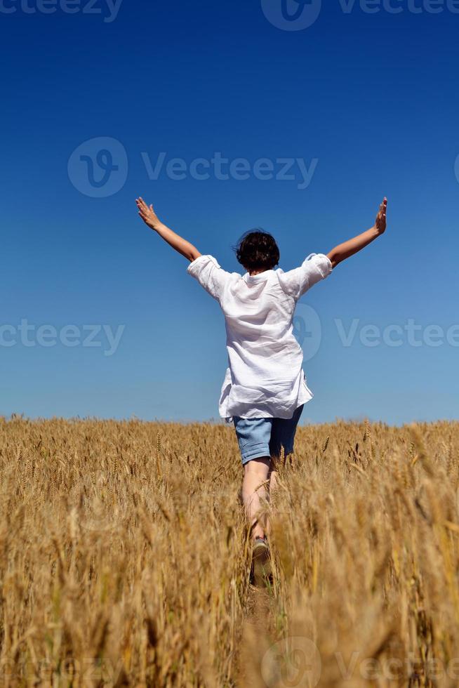 mujer joven en campo de trigo en verano foto