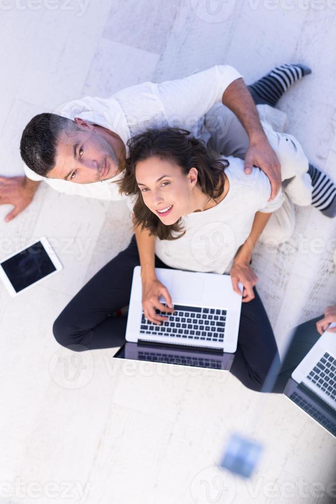 couple using tablet and laptop computers top view photo