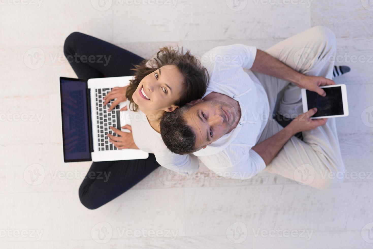 couple using tablet and laptop computers top view photo