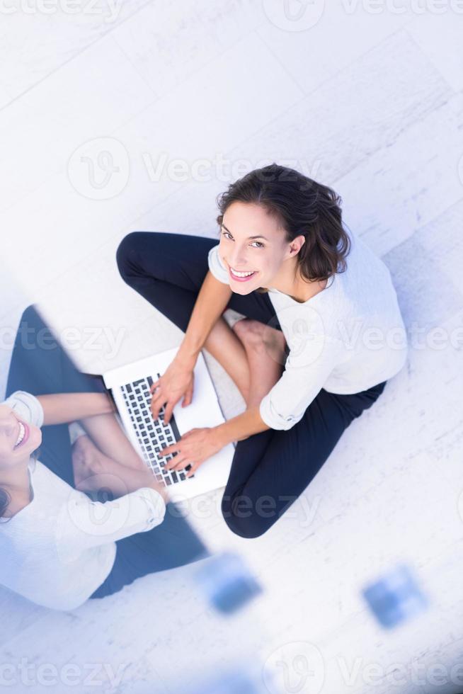 women using laptop computer on the floor top view photo
