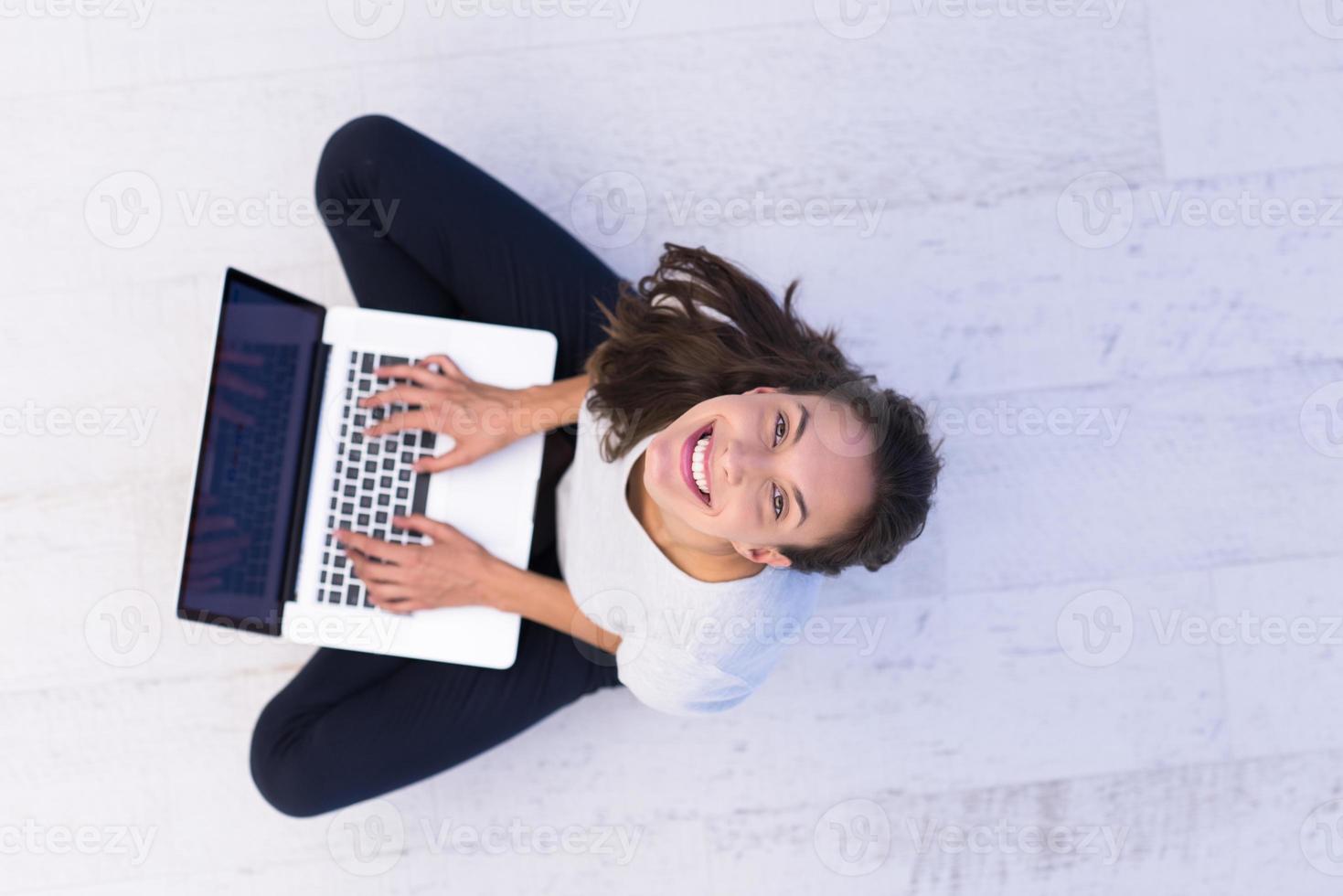 mujeres que usan una computadora portátil en la vista superior del piso foto