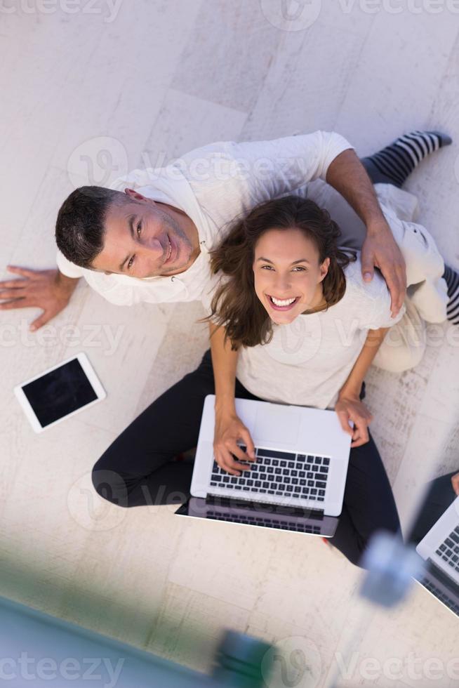 couple using tablet and laptop computers top view photo