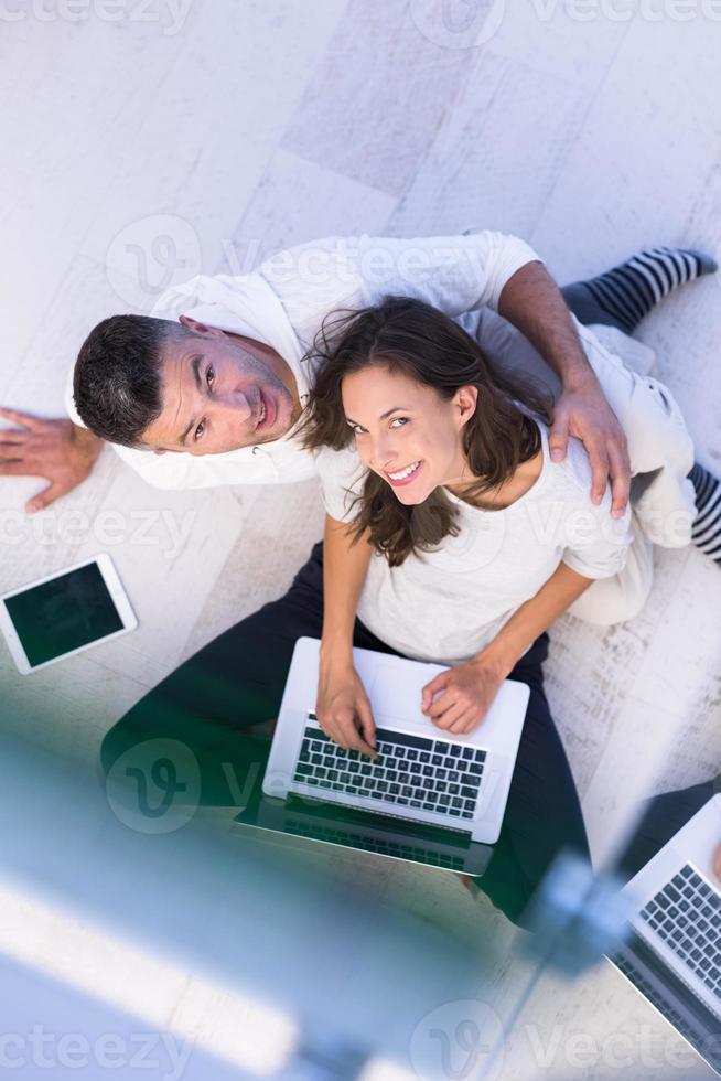 couple using tablet and laptop computers top view photo