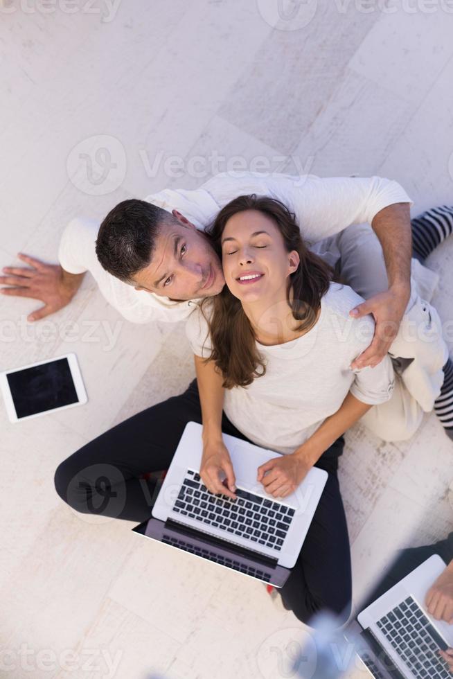 couple using tablet and laptop computers top view photo