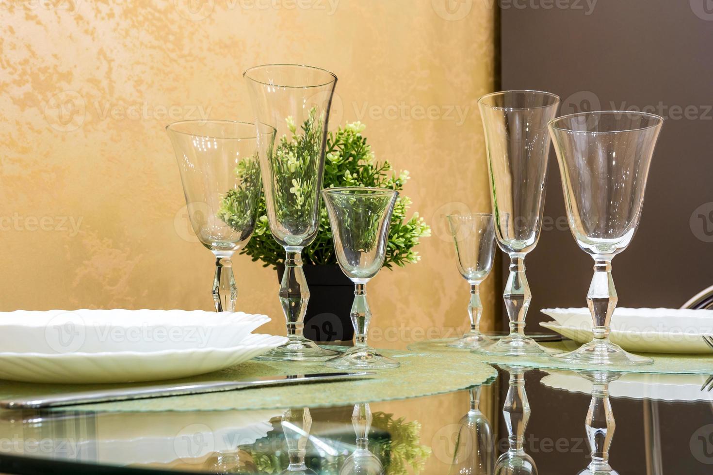 banquet table served with instruments and decorated with empty wine glasses photo