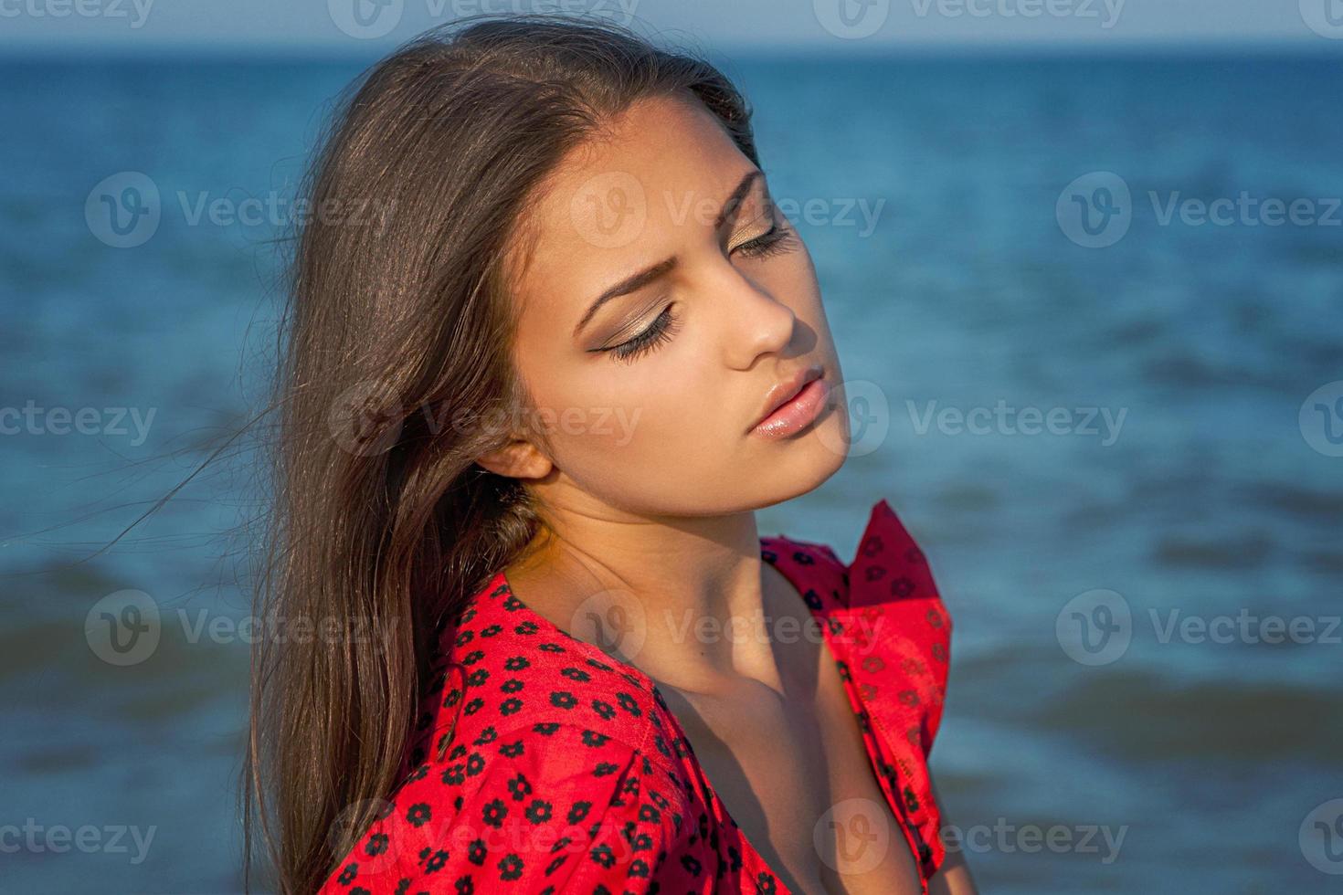 joven mujer triste cerca del mar en una puesta de sol foto