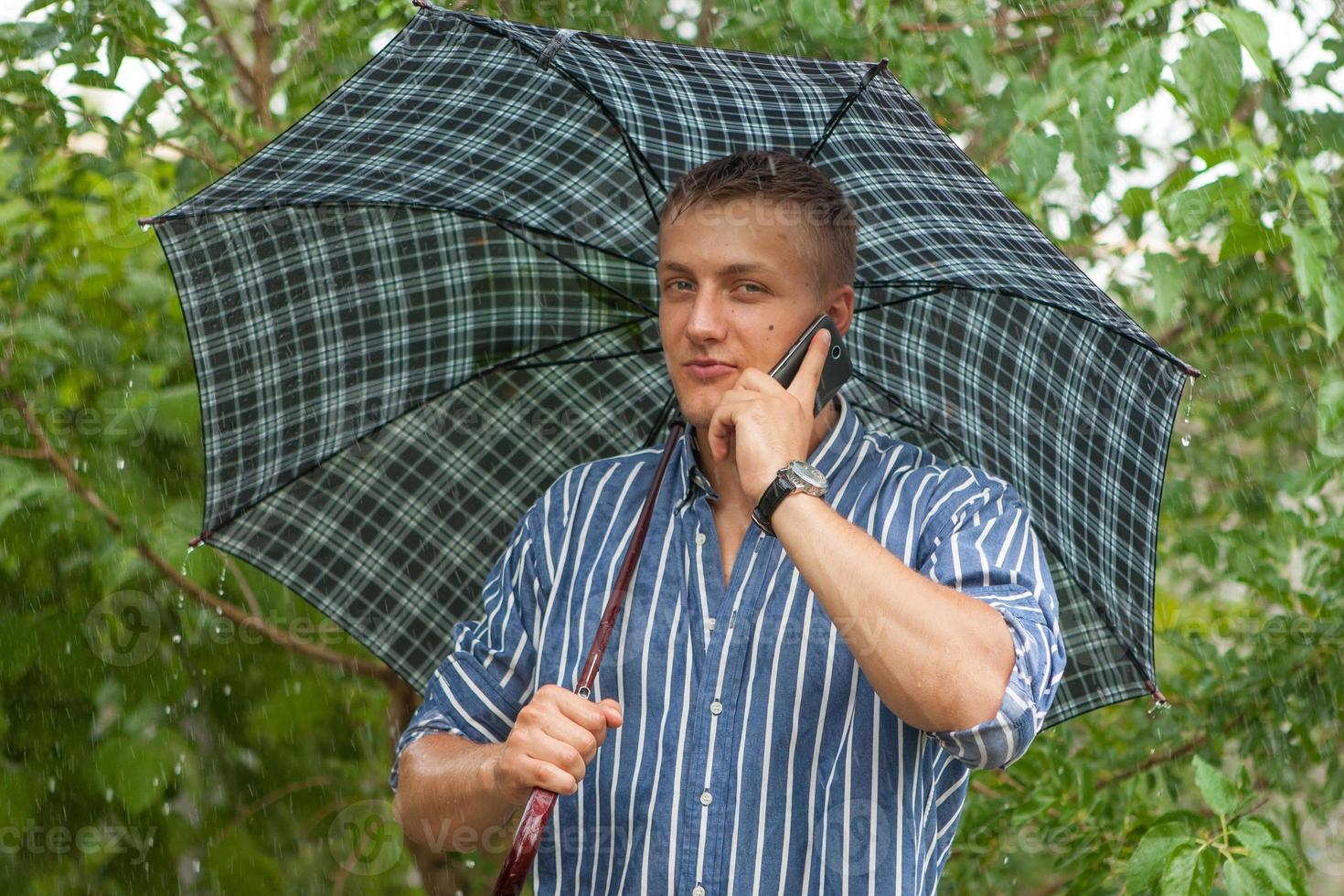 Man with umbrella and mobile phone photo