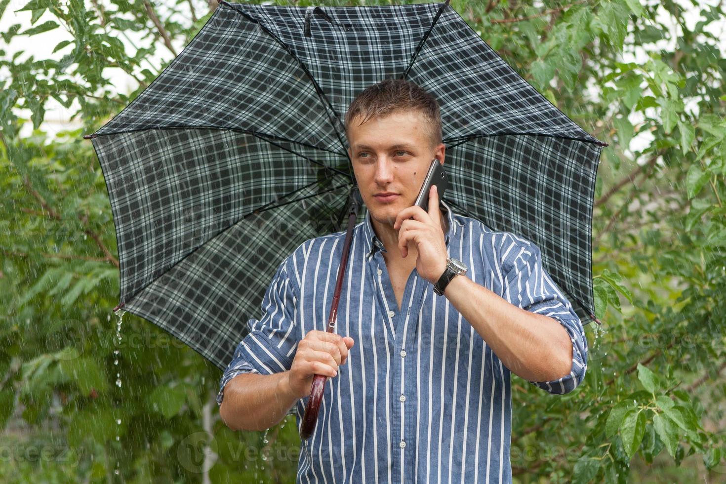 Man with umbrella and mobile phone photo