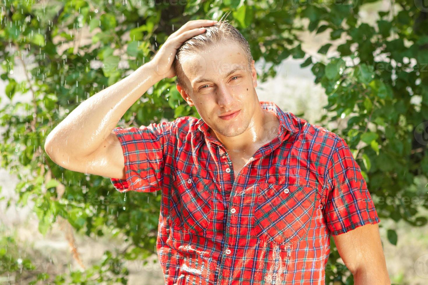 Sexy young man wet in rain photo