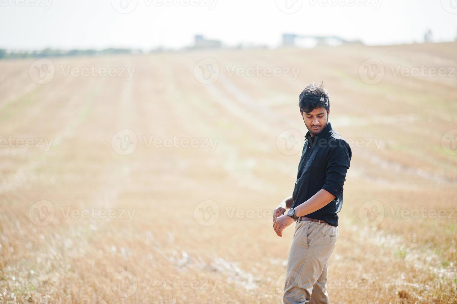 agricultor agrónomo del sur de asia inspeccionando la granja de campo de trigo. concepto de producción agrícola. foto