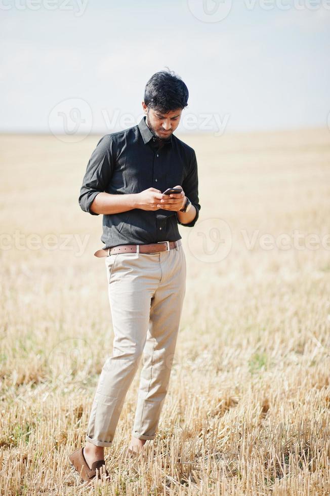 South asian agronomist farmer inspecting wheat field farm. Agriculture production concept. photo