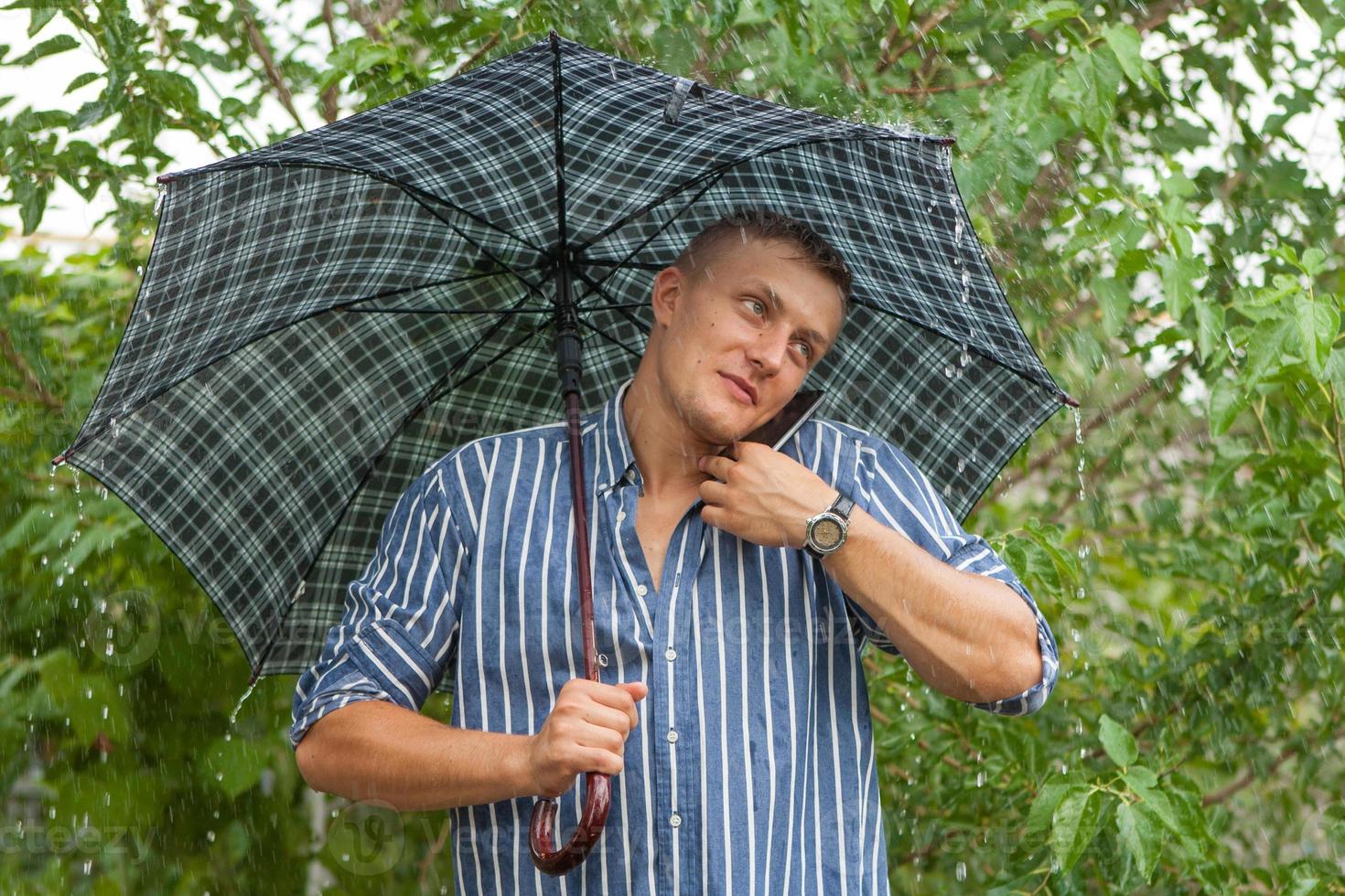 Man with umbrella and mobile phone photo