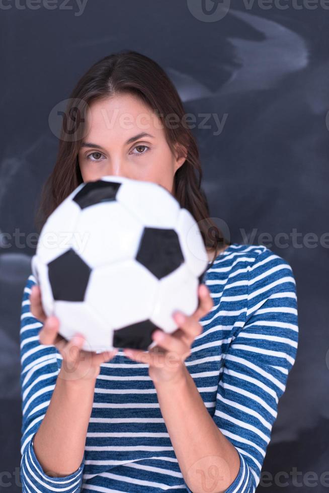 woman holding a soccer ball in front of chalk drawing board photo