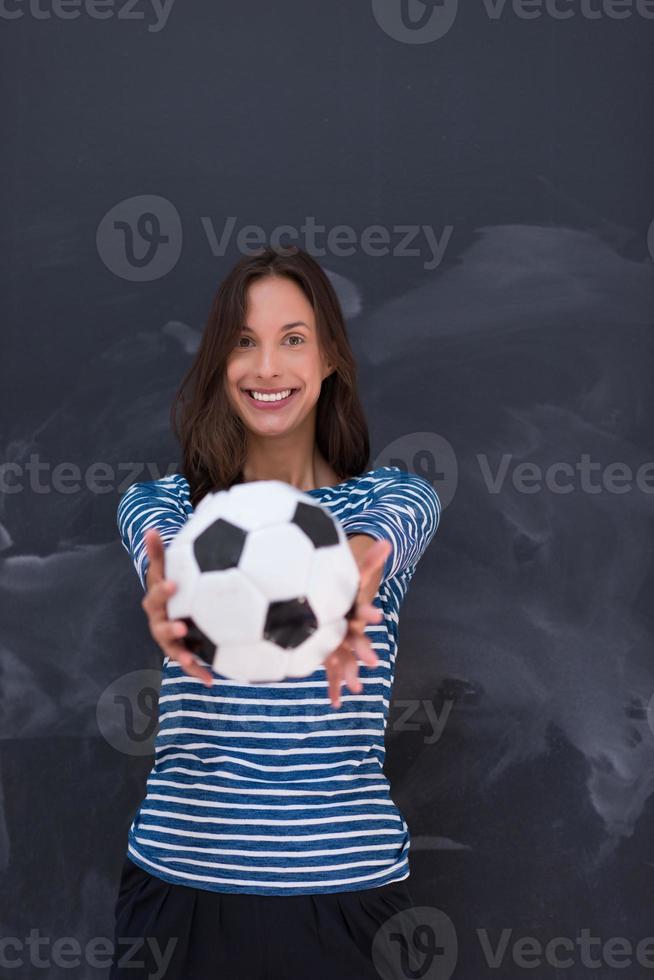 woman holding a soccer ball in front of chalk drawing board photo