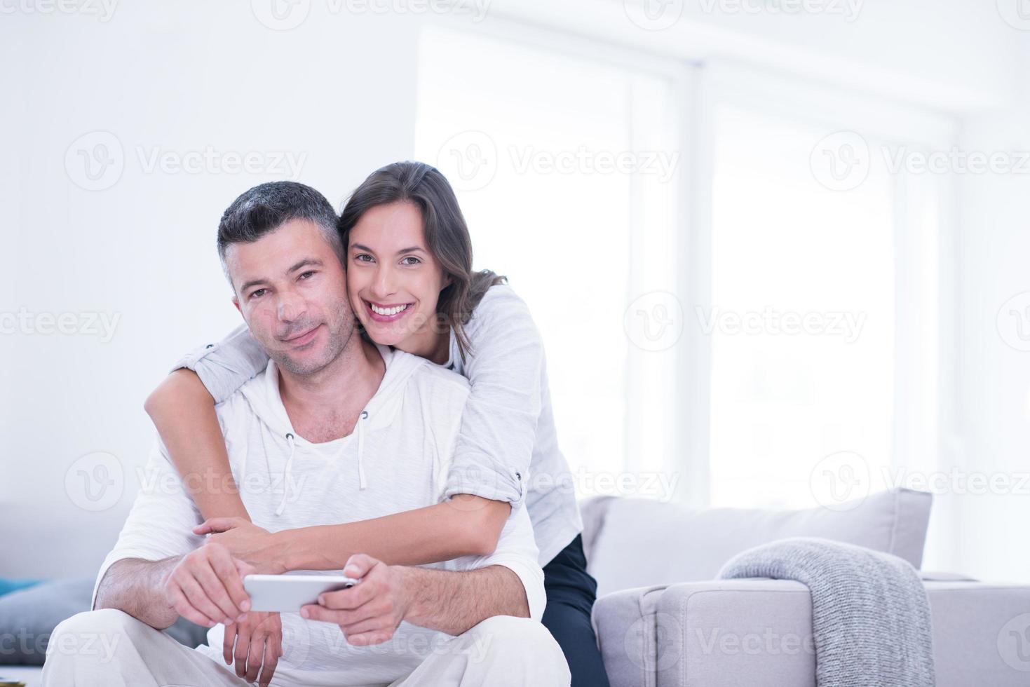 happy couple using mobile phone at home photo