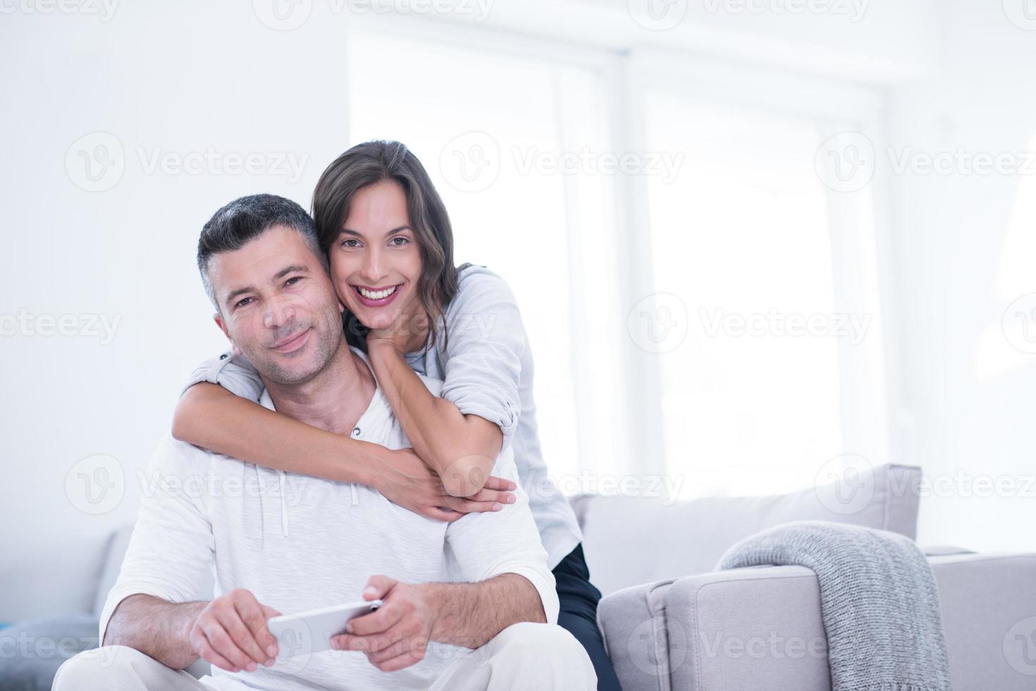 happy couple using mobile phone at home photo