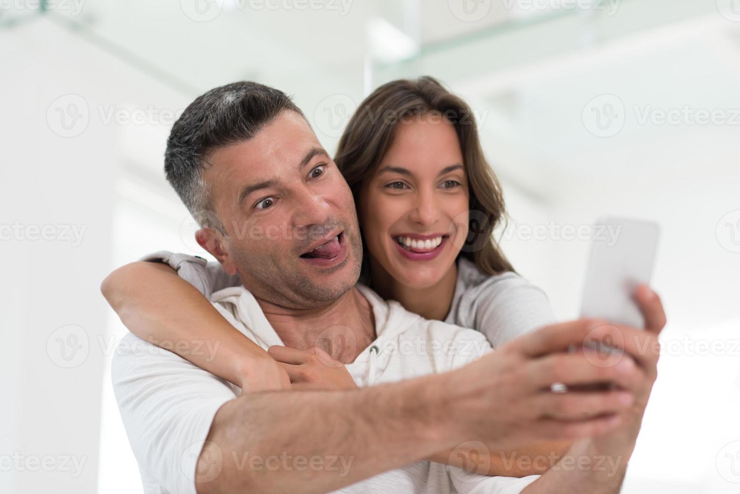 happy couple using mobile phone at home photo