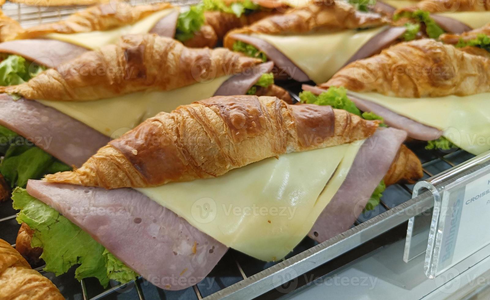 Closeup view. Croissant with ham and cheese on tray. photo