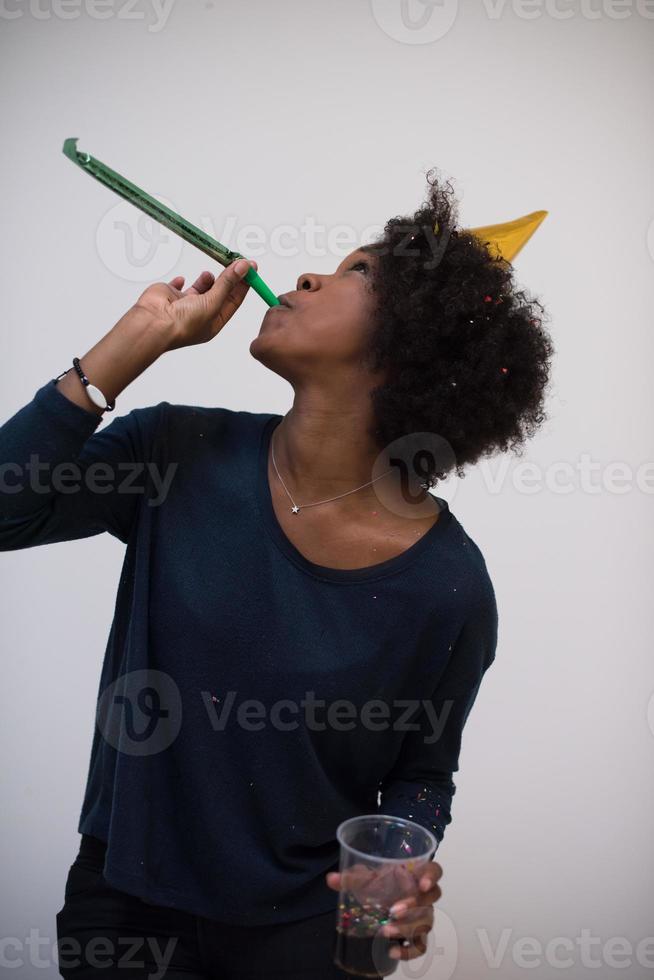 black woman in party hat blowing in whistle photo