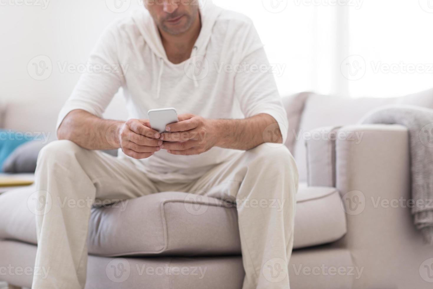 young man using a mobile phone  at home photo