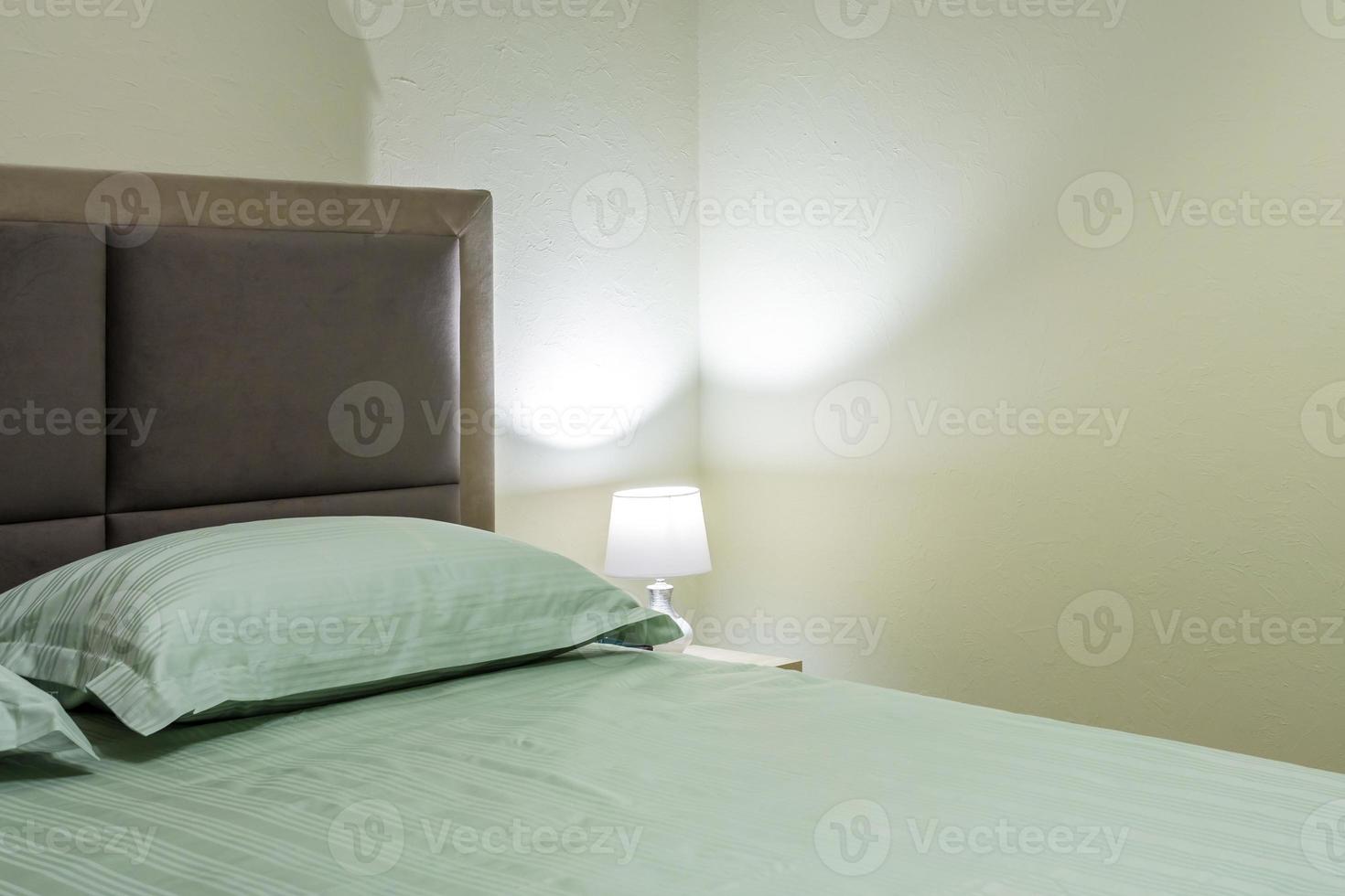 Double bed with pillows in interior of the modern intimate bedroom in loft flat in light color style apartments photo