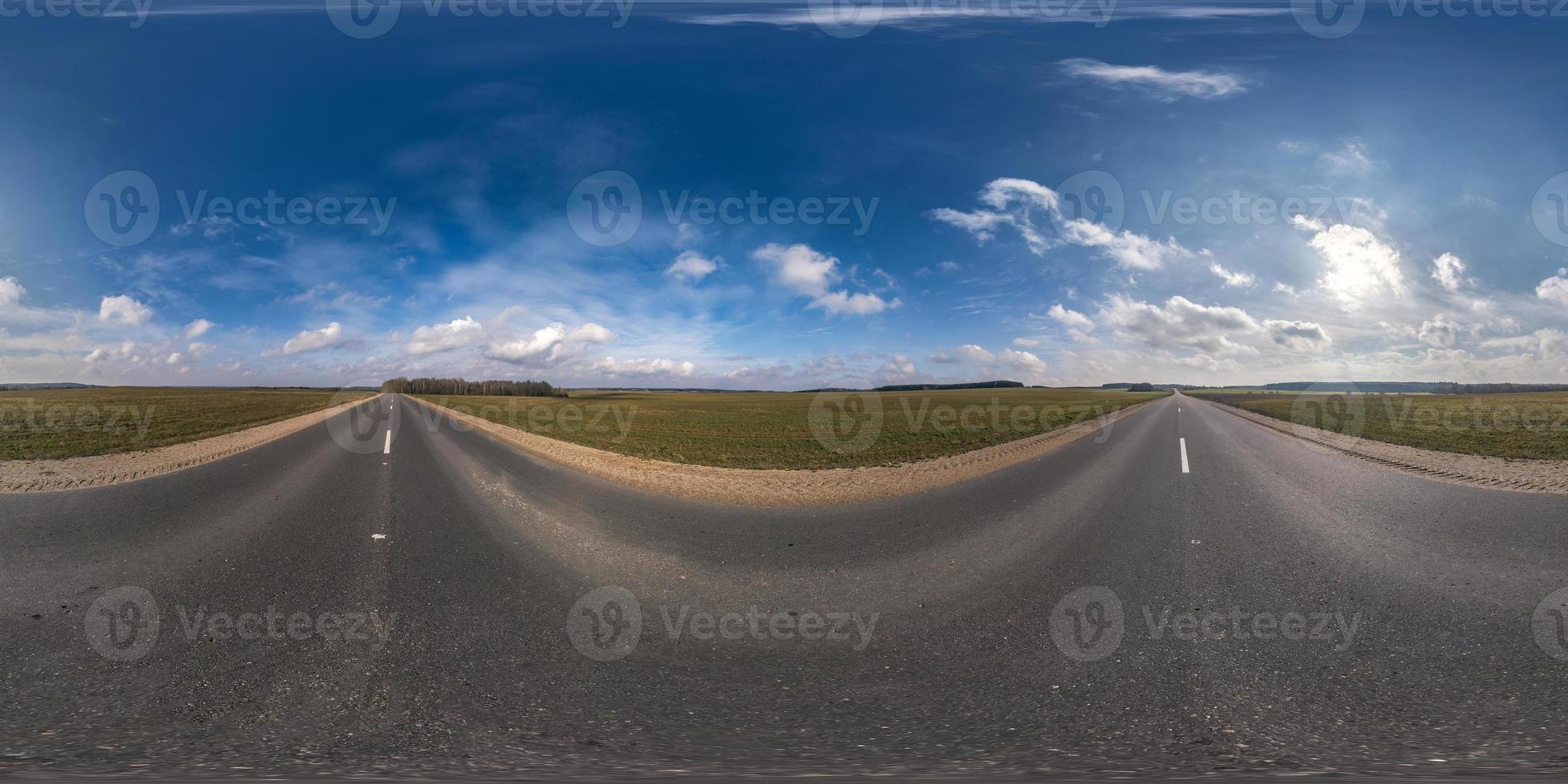 Panorama esférico completo sin costuras Vista angular de 360 grados en carretera asfaltada sin tráfico entre campos por la noche antes de la puesta del sol con cielo nublado. Panorama 360 en proyección equirrectangular, contenido vr ar foto