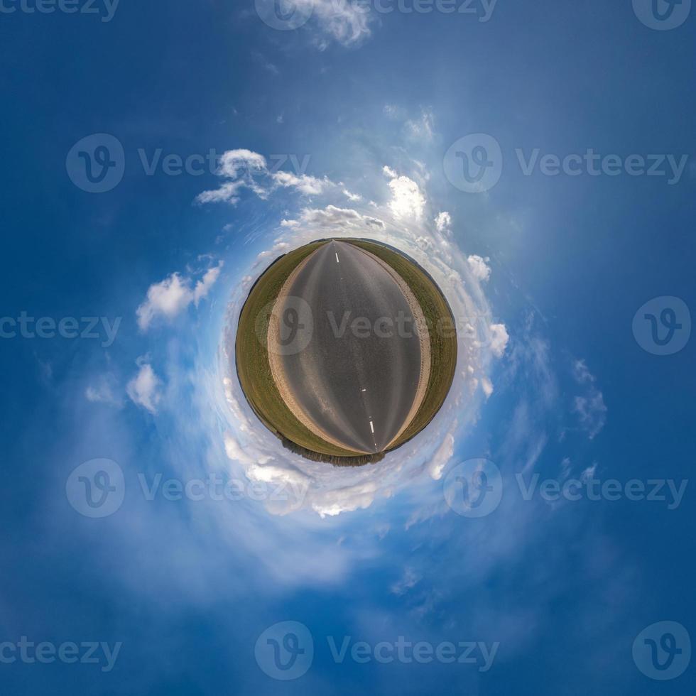 Little planet transformation of spherical panorama 360 degrees. Spherical abstract aerial view in field with awesome beautiful clouds. Curvature of space. photo
