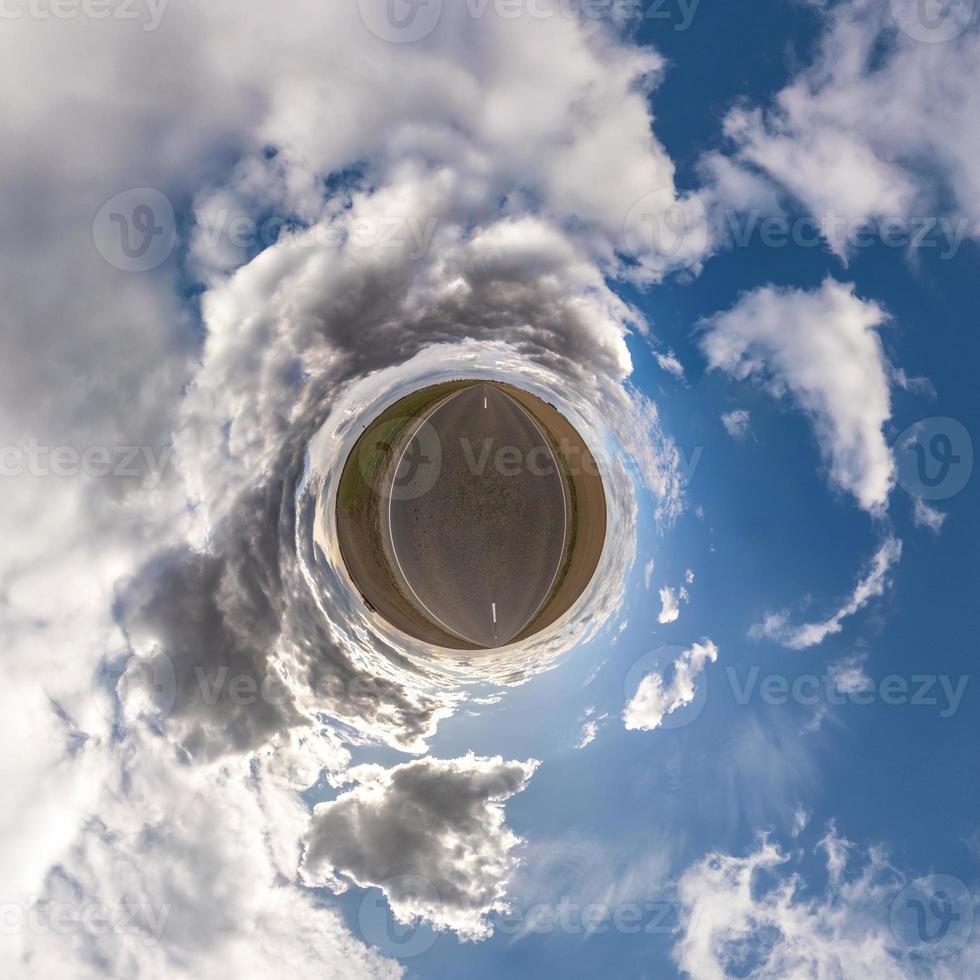 Little planet transformation of spherical panorama 360 degrees. Spherical abstract aerial view in field with awesome beautiful clouds. Curvature of space. photo