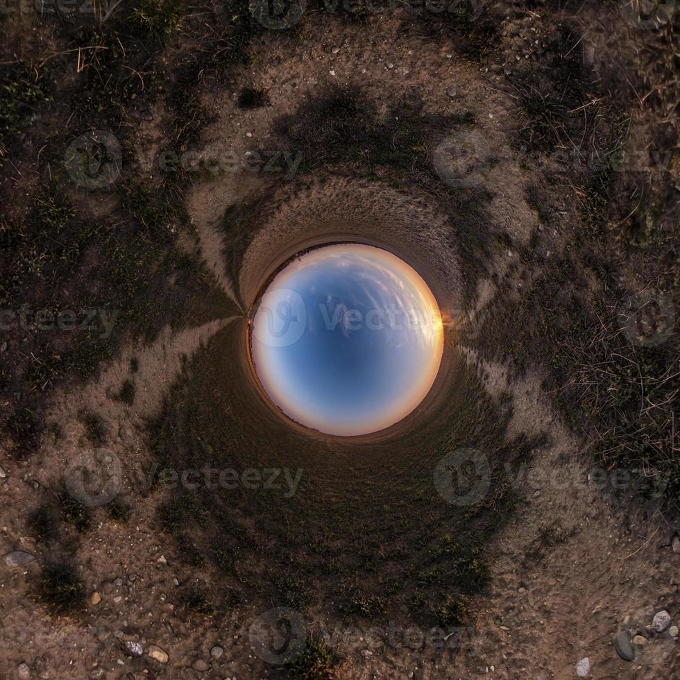 Inversion of little planet transformation of spherical panorama 360 degrees. Spherical abstract aerial view in field with awesome beautiful clouds. Curvature of space. photo