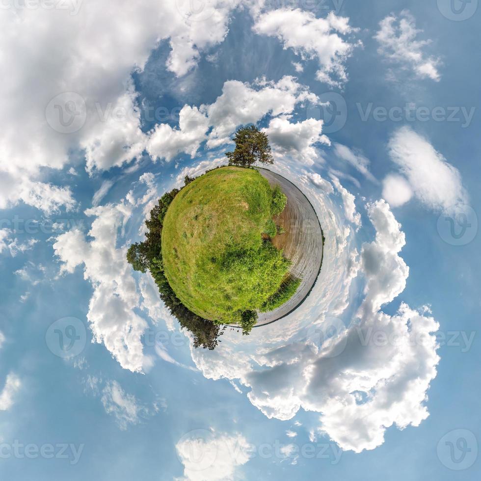 Little planet transformation of spherical panorama 360 degrees. Spherical abstract aerial view in field in nice evening with awesome beautiful clouds. Curvature of space. photo