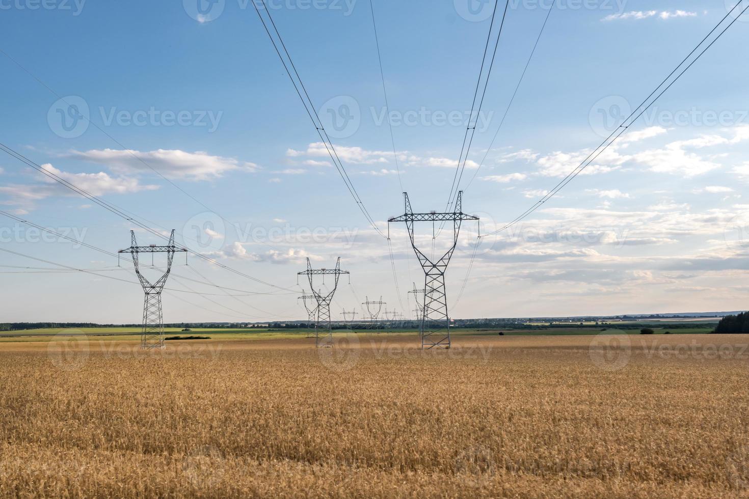 Silhouette of the high voltage electric pylon towers on the background of beautiful evening clouds photo