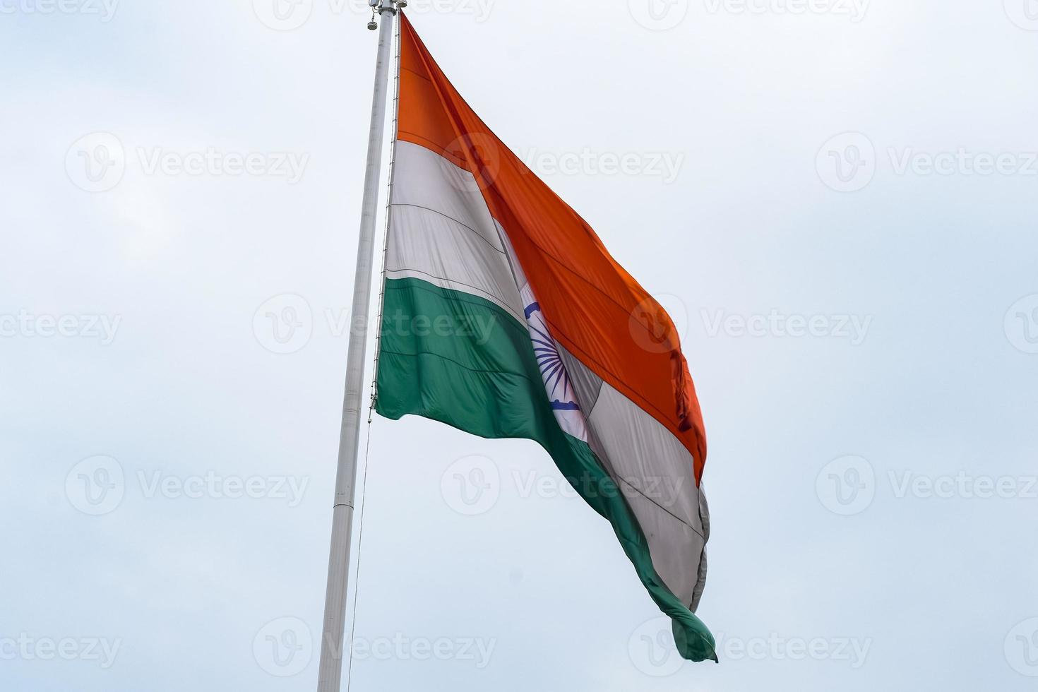 India flag flying high at Connaught Place with pride in blue sky, India flag fluttering, Indian Flag on Independence Day and Republic Day of India, tilt up shot, Waving Indian flag, Har Ghar Tiranga photo