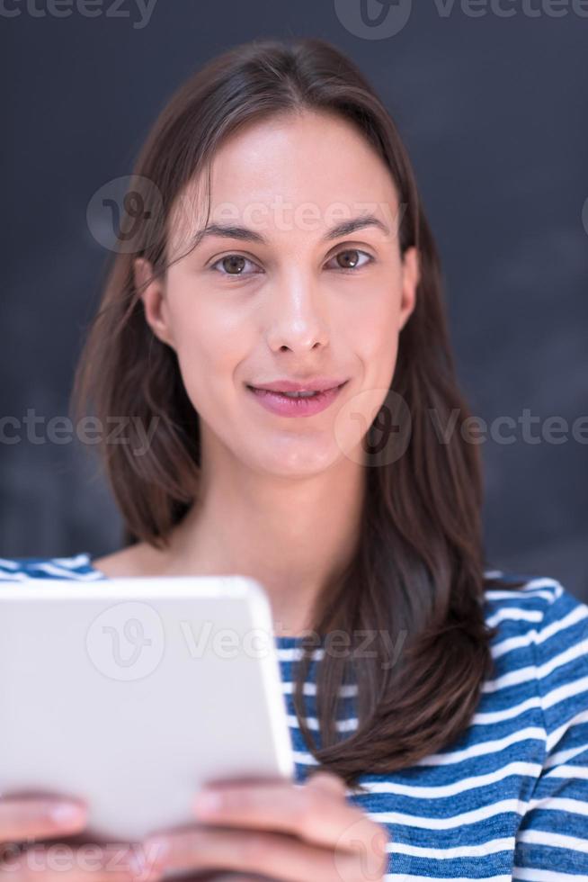 woman using tablet  in front of chalk drawing board photo