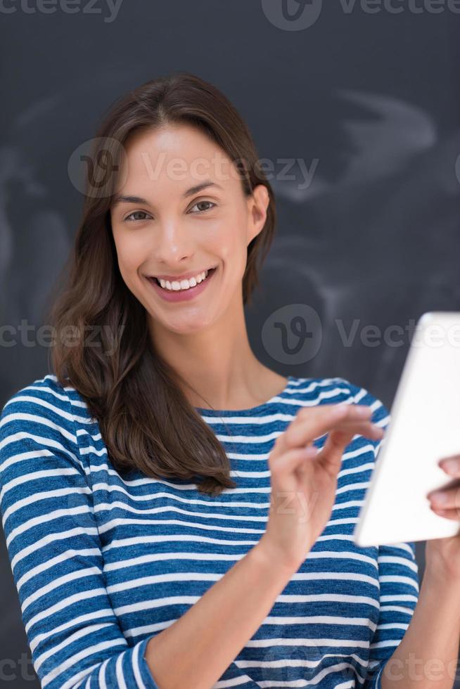 woman using tablet  in front of chalk drawing board photo