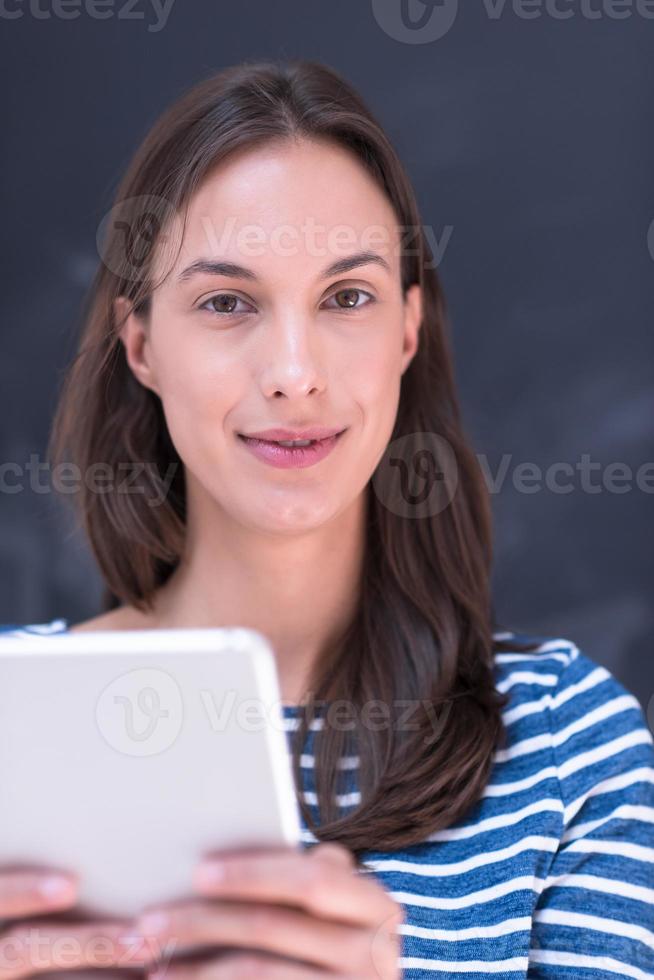 woman using tablet  in front of chalk drawing board photo