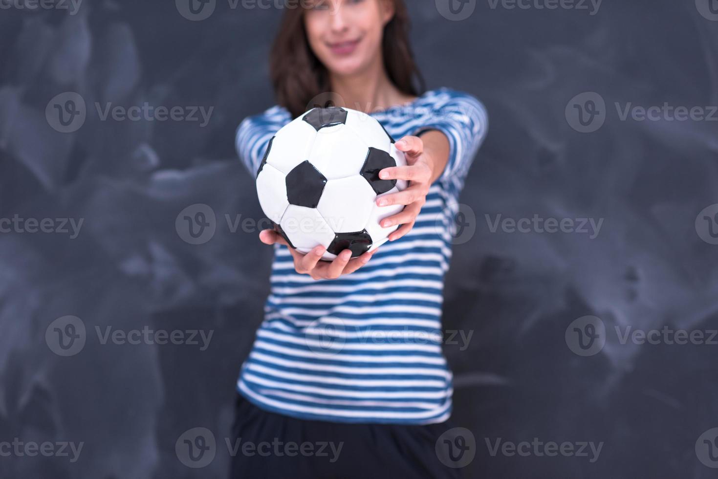 woman holding a soccer ball in front of chalk drawing board photo