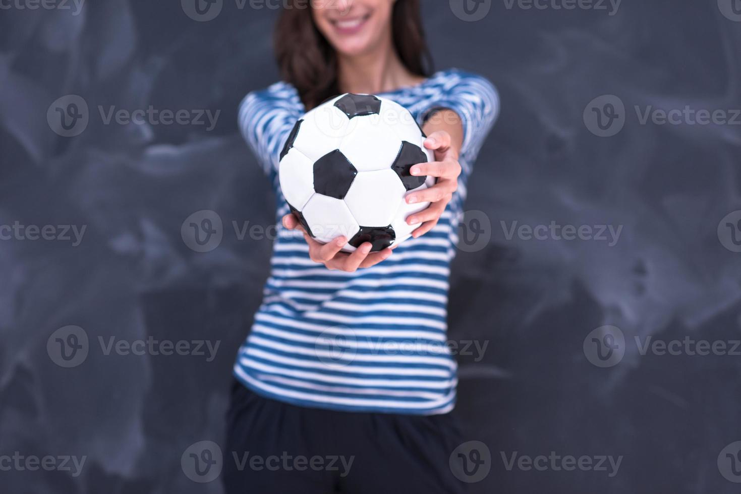 woman holding a soccer ball in front of chalk drawing board photo