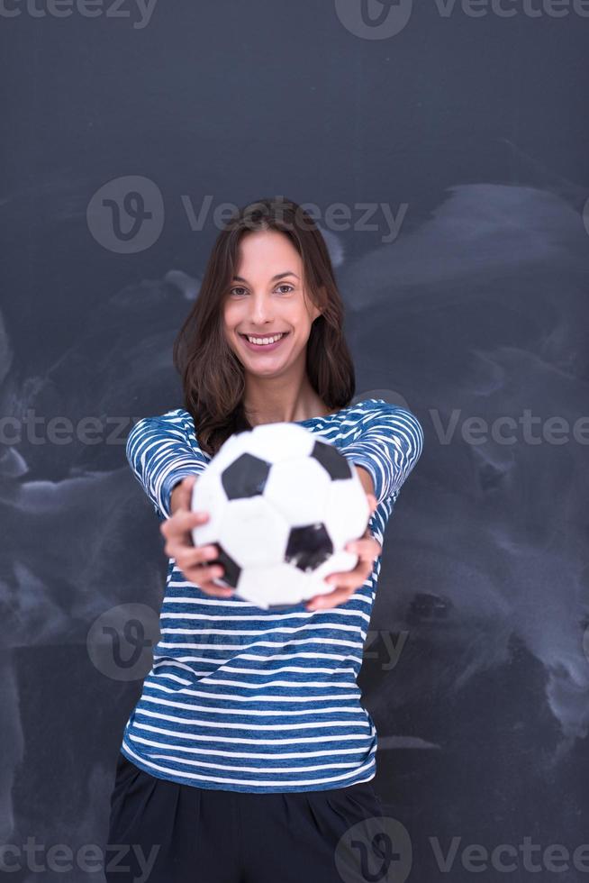 woman holding a soccer ball in front of chalk drawing board photo