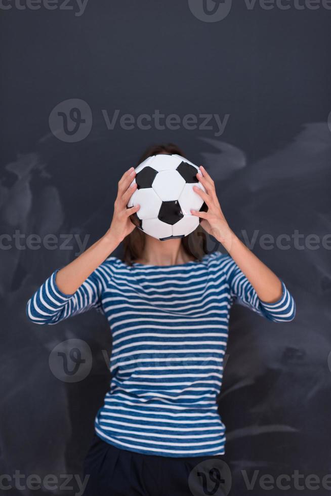 woman holding a soccer ball in front of chalk drawing board photo