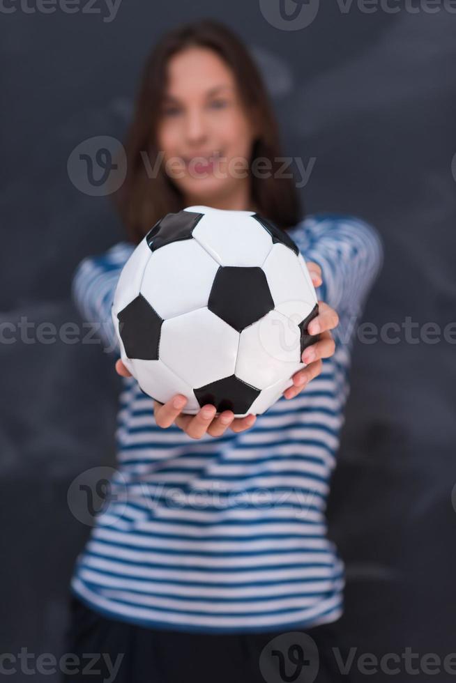 woman holding a soccer ball in front of chalk drawing board photo