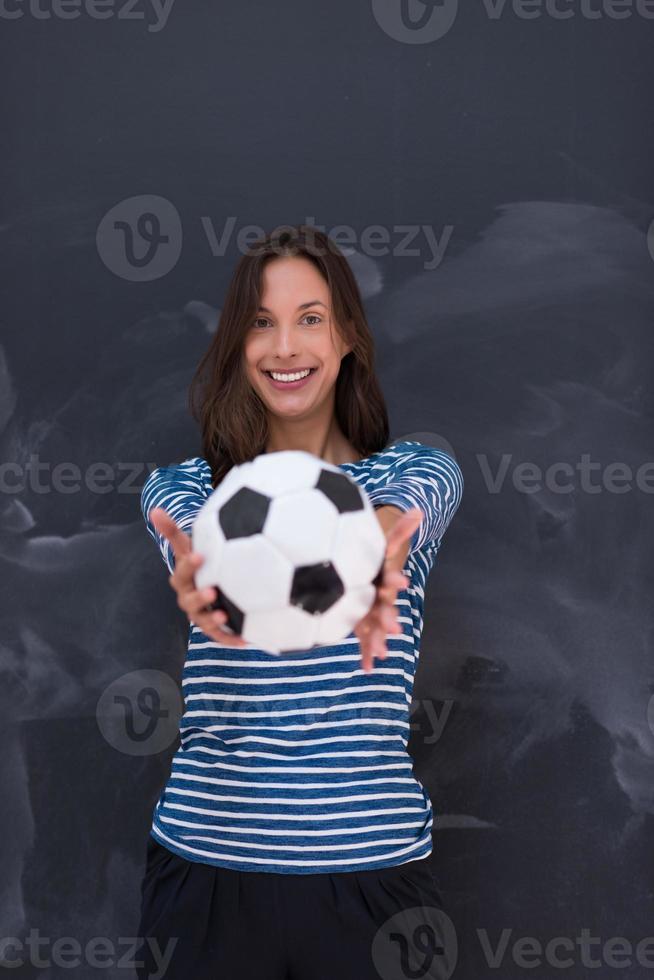 woman holding a soccer ball in front of chalk drawing board photo