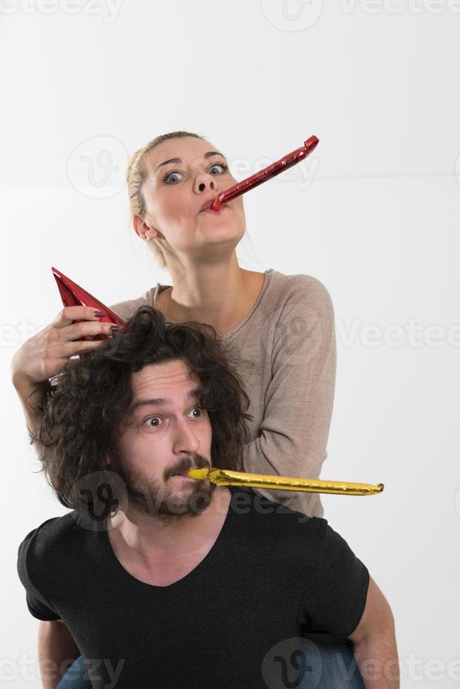 couple in party hats blowing in whistle photo