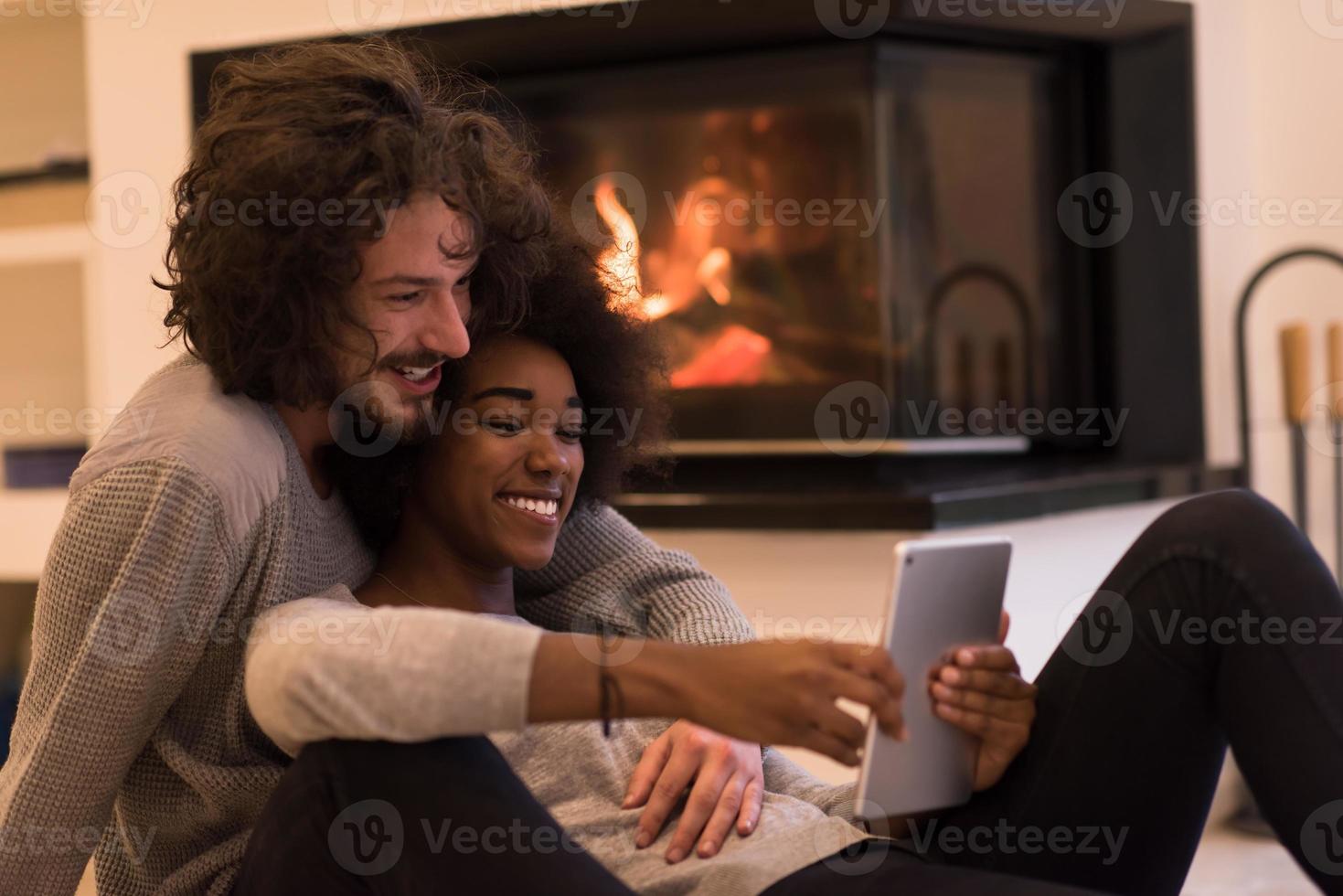 multiethnic couple using tablet computer on the floor photo