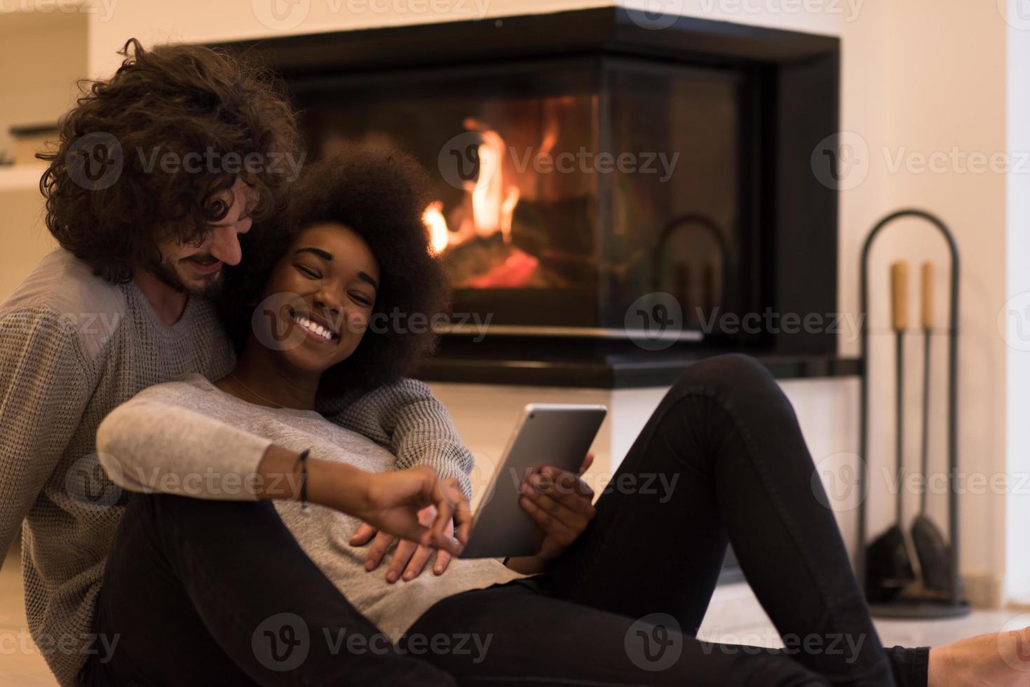 multiethnic couple using tablet computer on the floor photo