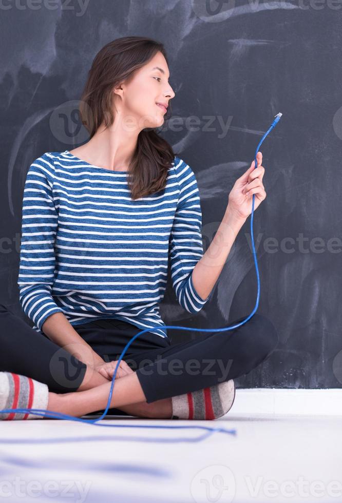 woman holding a internet cable in front of chalk drawing board photo